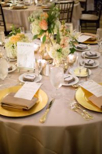 A wedding table with plates, appetizers, and a centerpiece