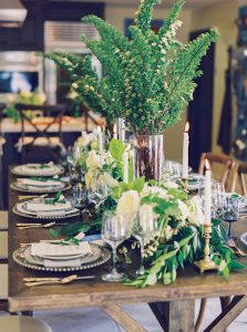 A wooden table with multiple plates and centerpieces