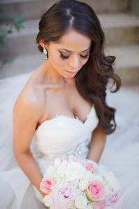 A brown-haired bride looking at her flowers
