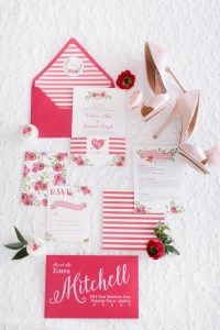 A magenta and white wedding invitation set