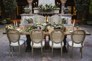 A fancy dining table with various floral arrangements