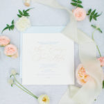 A custom wedding invite surrounded by flowers