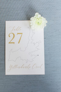 Custom table number is an illustration of Hayden Lake with landmarks around the lake
